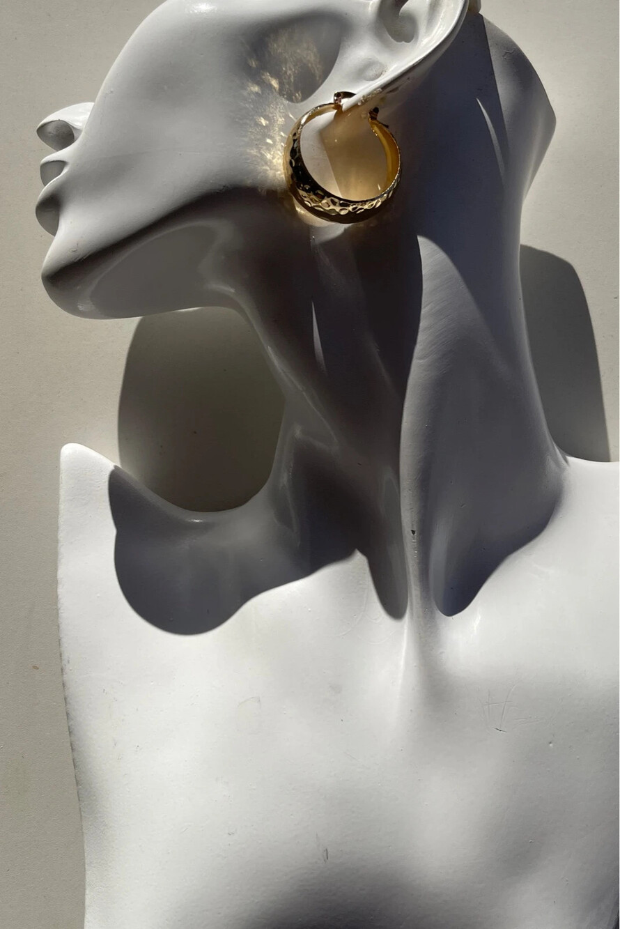 chunky gold hoop earrings with a textured or hammered finish